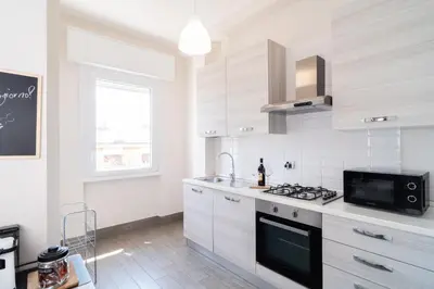 a kitchen with white cabinets and a stove top oven at RomeCornelia Apartment - Musei Vaticani - San Pietro in Rome