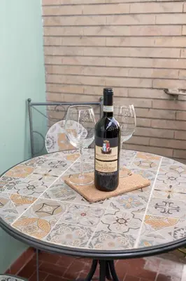 a bottle of wine sitting on a table with two wine glasses at RomeCornelia Apartment - Musei Vaticani - San Pietro in Rome