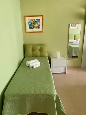 a bedroom with a green bed and a mirror at Alloggio di Raffaello L in Rome
