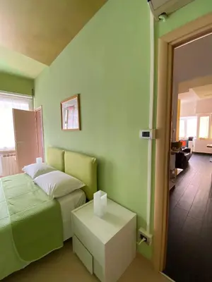 a green bedroom with a bed and a table at Alloggio di Raffaello L in Rome