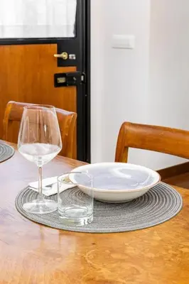 a table with a plate and a glass of wine at Bottega Augustea Duplex apartment in Monti in Rome