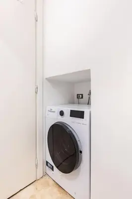 a white washer and dryer in a white room at Bottega Augustea Duplex apartment in Monti in Rome