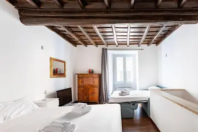a room with two beds and a window in it at Bottega Augustea Duplex apartment in Monti in Rome
