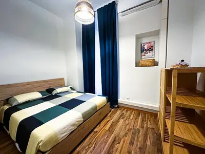 a bedroom with a bed and a window with blue curtains at Giulio Cesare 237 in Rome
