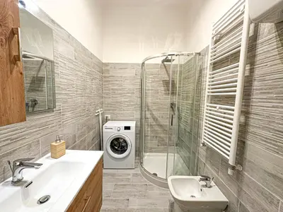 a bathroom with a sink and a washing machine at Giulio Cesare 237 in Rome