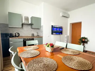a dining room with a table and chairs and a kitchen at Giulio Cesare 237 in Rome