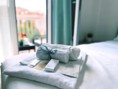 a pile of towels and a book on a bed at Bella Boutique in Rome