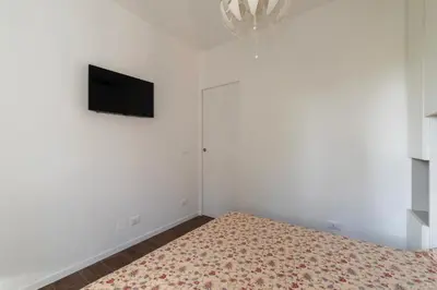 a bedroom with a bed and a tv on a wall at GuestHost - Monteverde Classy Apartment in Rome