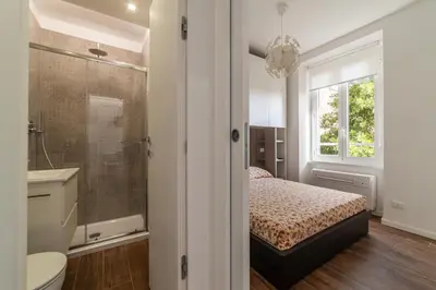 a bedroom with a bed and a shower and a sink at GuestHost - Monteverde Classy Apartment in Rome