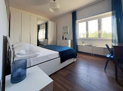a bedroom with a large white bed and a window at Trastevere Station House in Rome