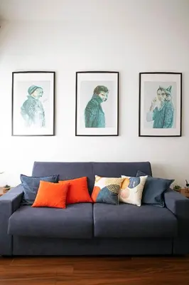 a blue couch in a living room with framed pictures at Trastevere Station House in Rome