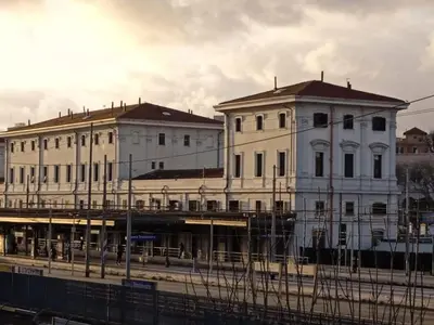 two large white buildings next to a train station at Trastevere Station House in Rome