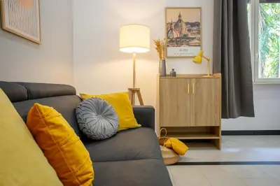 a living room with a gray couch with yellow pillows at Mustard Apartment S Camillo - Holiday Homes Rome in Rome