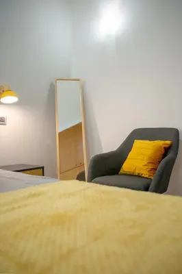 a bedroom with a yellow pillow and a chair at Mustard Apartment S Camillo - Holiday Homes Rome in Rome