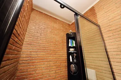 a room with a brick wall with a glass door at Vatican Luxury Apt with Garden in Rome