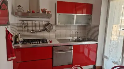 a kitchen with red cabinets and a red stove at Via Tiburtina vicino Università e Stazione intero appartamento per la tua vacanza a Roma in Rome