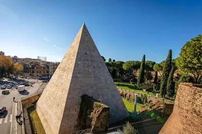 a pyramid shaped monument in a city with a street at Ostiense upsidedown in Rome
