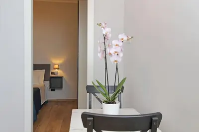 a table and chair with a vase with flowers on it at Ostiense upsidedown in Rome