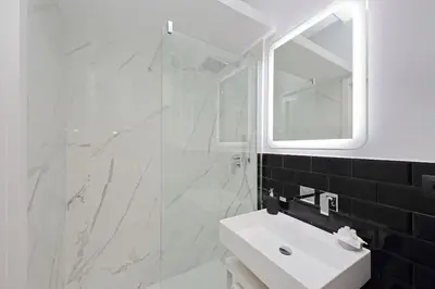 a white bathroom with a sink and a mirror at Ostiense upsidedown in Rome