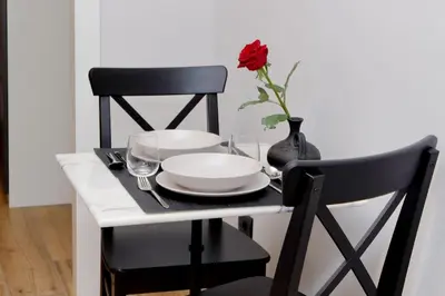 a table with a plate and a vase with a rose at Ostiense upsidedown in Rome