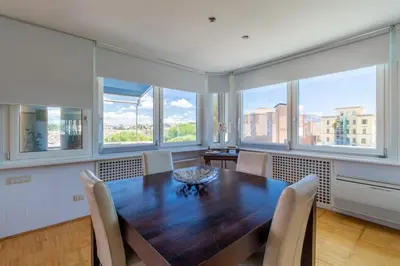 a dining room with a table and chairs and windows at Imperial Rome Accommodation terrazza sul vaticano in Rome