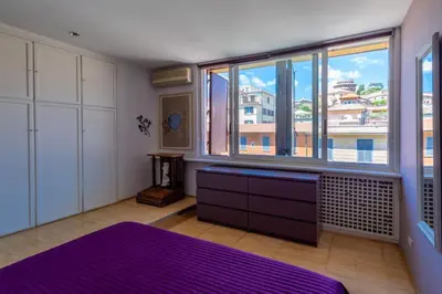 a bedroom with a purple bed and a large window at Imperial Rome Accommodation terrazza sul vaticano in Rome