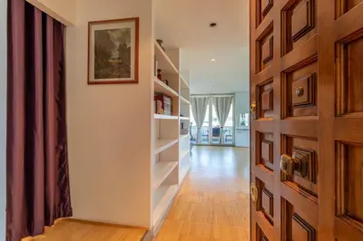a hallway with white shelves and a wooden door at Imperial Rome Accommodation terrazza sul vaticano in Rome