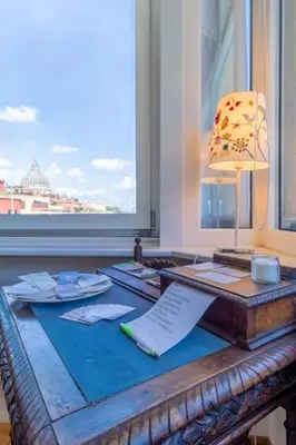 a wooden table with a desk with a lamp and a window at Imperial Rome Accommodation terrazza sul vaticano in Rome