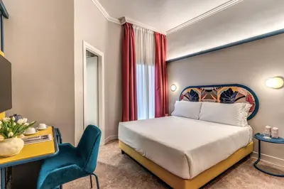 a hotel room with a bed and a chair at Hotel XX Settembre in Rome