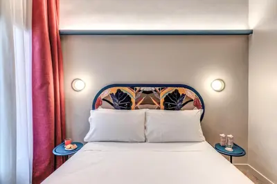 a bedroom with a bed with a headboard and two tables at Hotel XX Settembre in Rome
