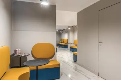 a waiting room with yellow chairs and a table at Hotel XX Settembre in Rome