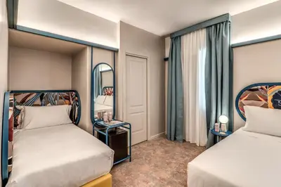 a hotel room with two beds and a mirror at Hotel XX Settembre in Rome