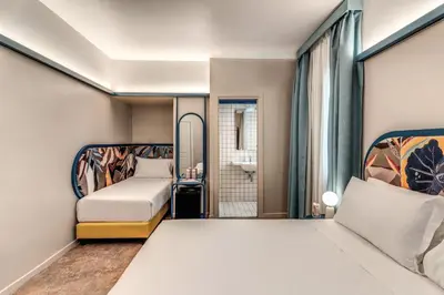 a hotel room with two beds and a window at Hotel XX Settembre in Rome