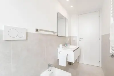 a white bathroom with a sink and a mirror at Appartamento Basilica di San Giovanni in Laterano in Rome