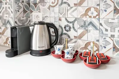 a coffee pot and cups on a counter next to a microwave at Appartamento Basilica di San Giovanni in Laterano in Rome