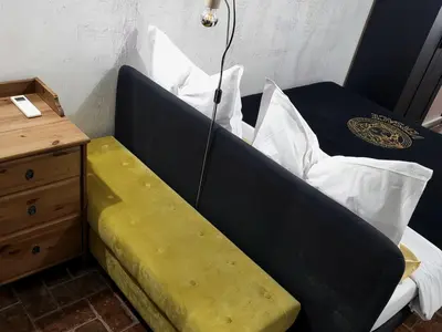 a black bed with white pillows next to a night stand at Antica Trasteverina in Rome