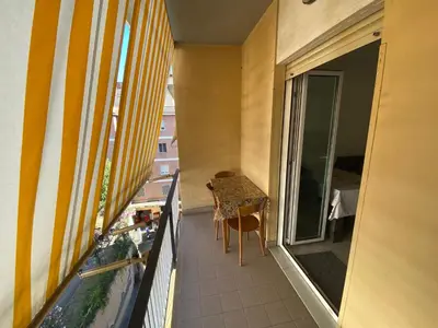 a balcony with a table and a window with a surfboard at Malu's house in Rome