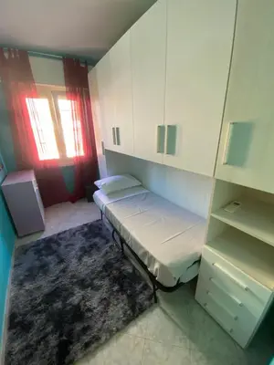 a small room with a bed and cabinets and a rug at Malu's house in Rome