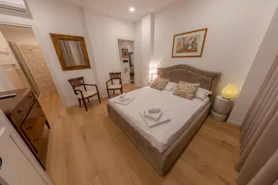 a small bedroom with a bed and two chairs at Gaia's home in Vatican in Rome