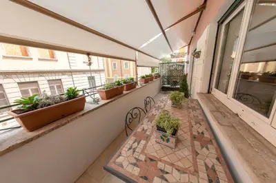 an empty balcony with potted plants and a table at Gaia's home in Vatican in Rome