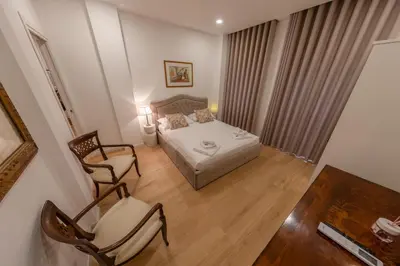 a small bedroom with a bed and two chairs at Gaia's home in Vatican in Rome