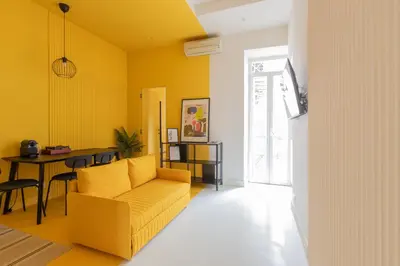 a yellow living room with a yellow couch and a table at Reale Vatican House in Rome