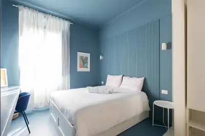 a bedroom with a large bed with blue walls at Reale Vatican House in Rome