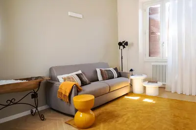 a living room with a gray couch and a yellow stool at Testaccio Design Apartment Rome in Rome