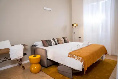 a bedroom with a bed and a yellow stool at Testaccio Design Apartment Rome in Rome