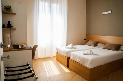 a hotel room with two beds and a chair at Testaccio Design Apartment Rome in Rome