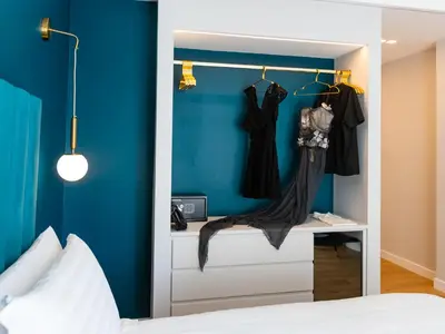 a bedroom with blue walls and a closet with dresses at Regola Luxury Relais in Rome
