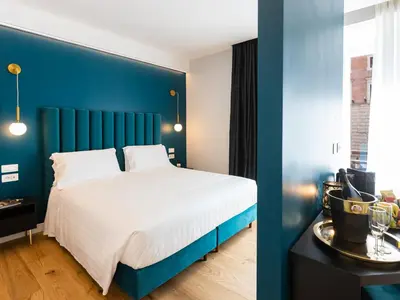 a bedroom with a large bed with a blue headboard at Regola Luxury Relais in Rome