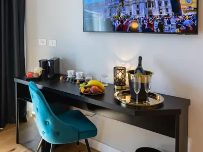 a desk with a blue chair and a bottle of wine at Regola Luxury Relais in Rome