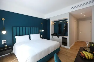 a bedroom with a white bed and a blue wall at Regola Luxury Relais in Rome